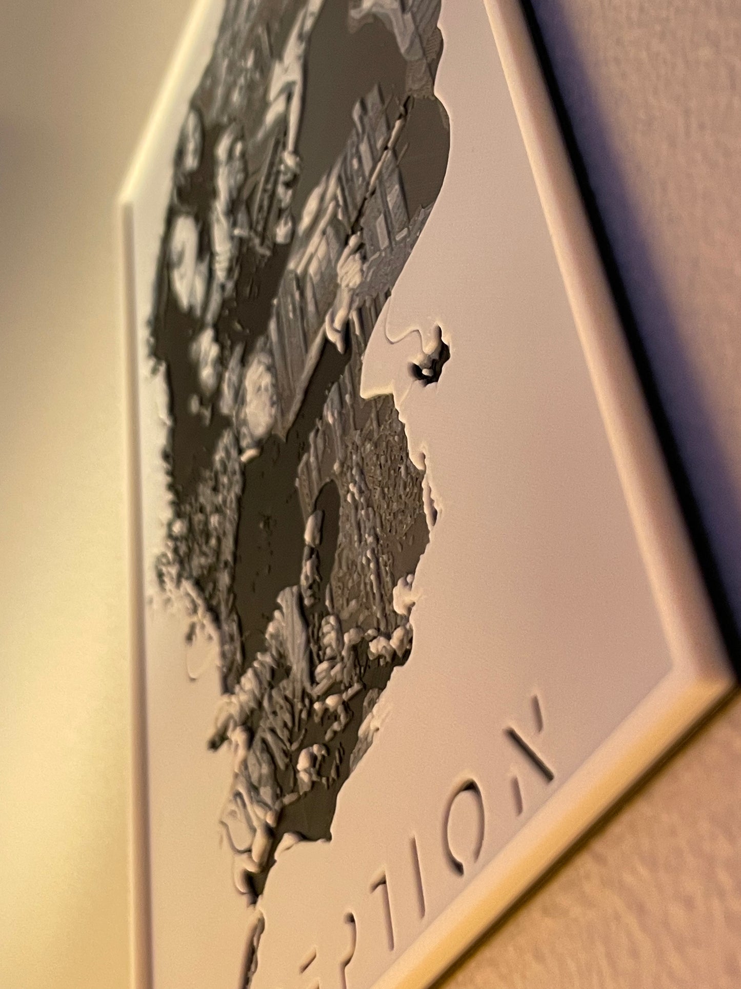 Metallic wall art with a face design and inception branding on a neutral background