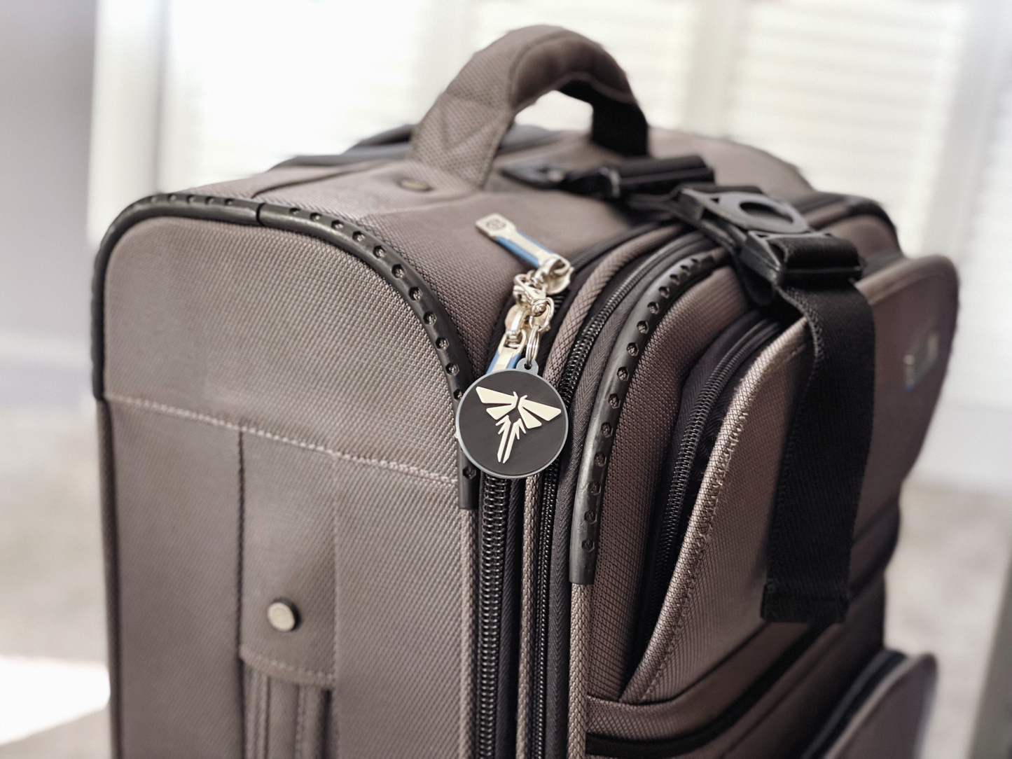 Brown suitcase with a visible brand logo on a light background