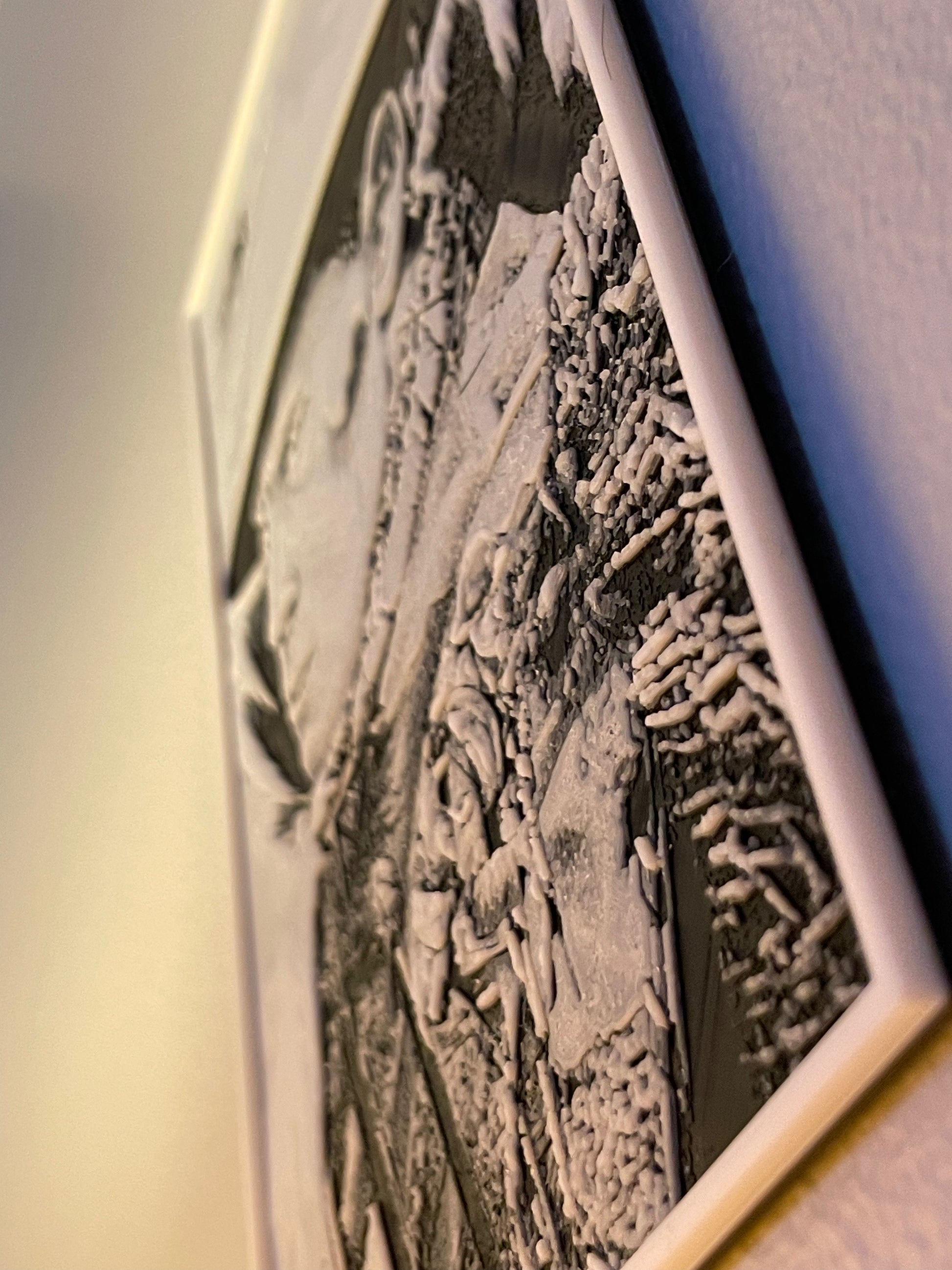 Close-up of a textured wall art piece with a neutral background