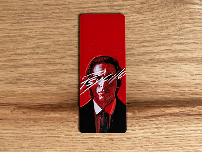 Rectangular red card with a stylized portrait on a wooden surface