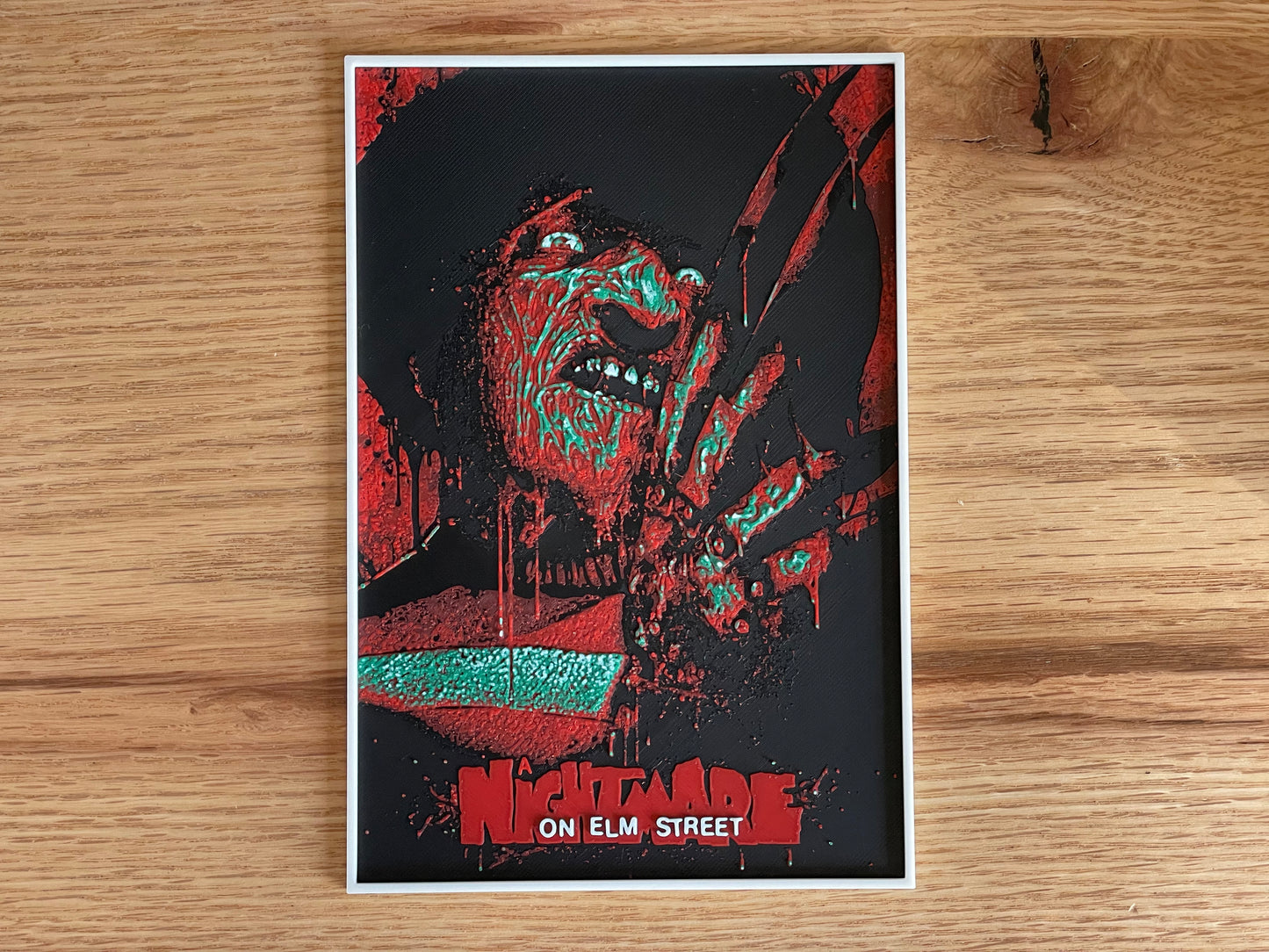 Poster of a character from 'Nightmare on Elm Street' on a wooden surface