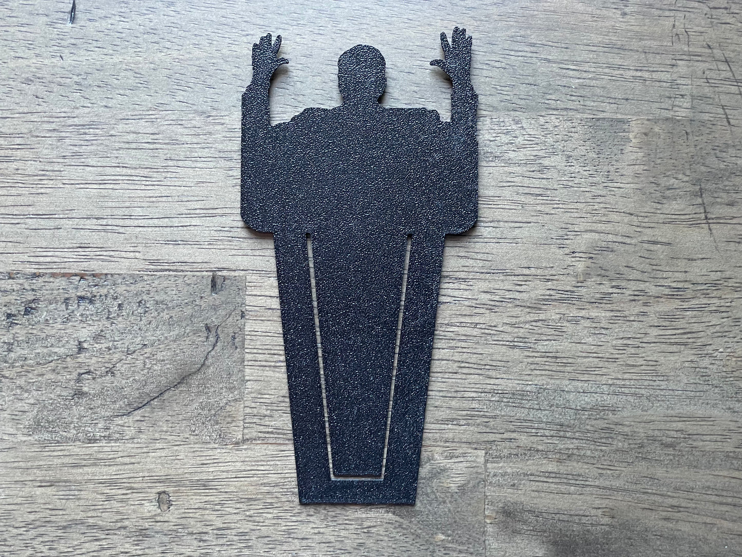 Silhouette of a person with arms raised on a textured surface