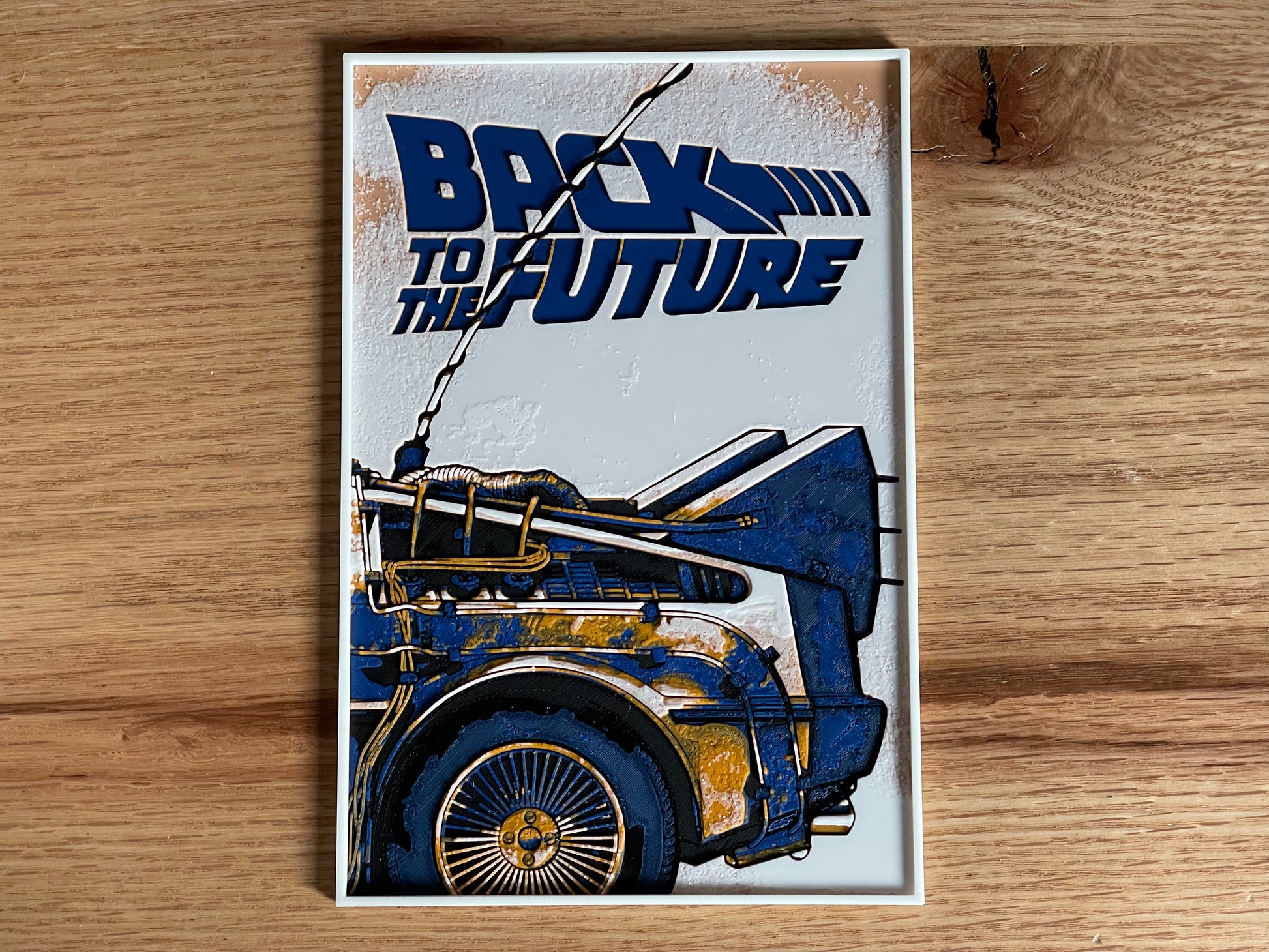 Poster of 'Back to the Future' with a blue and gold car design on a wooden surface.