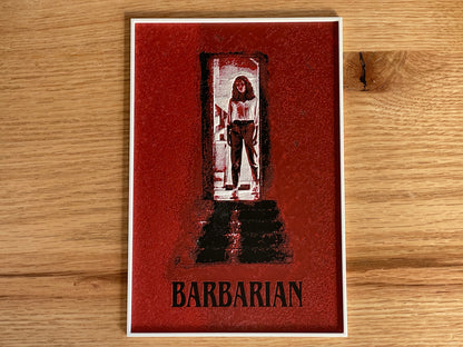 Card with a stylized illustration of a character in a doorway and the word 'Barbarian' on a wooden surface.