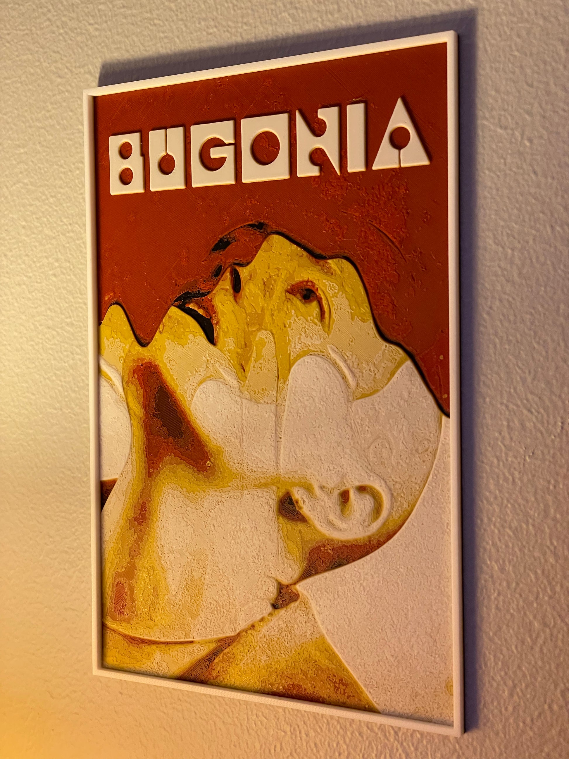 Decorative wall art with a stylized face and 'BUGONIA' text on a brown background.