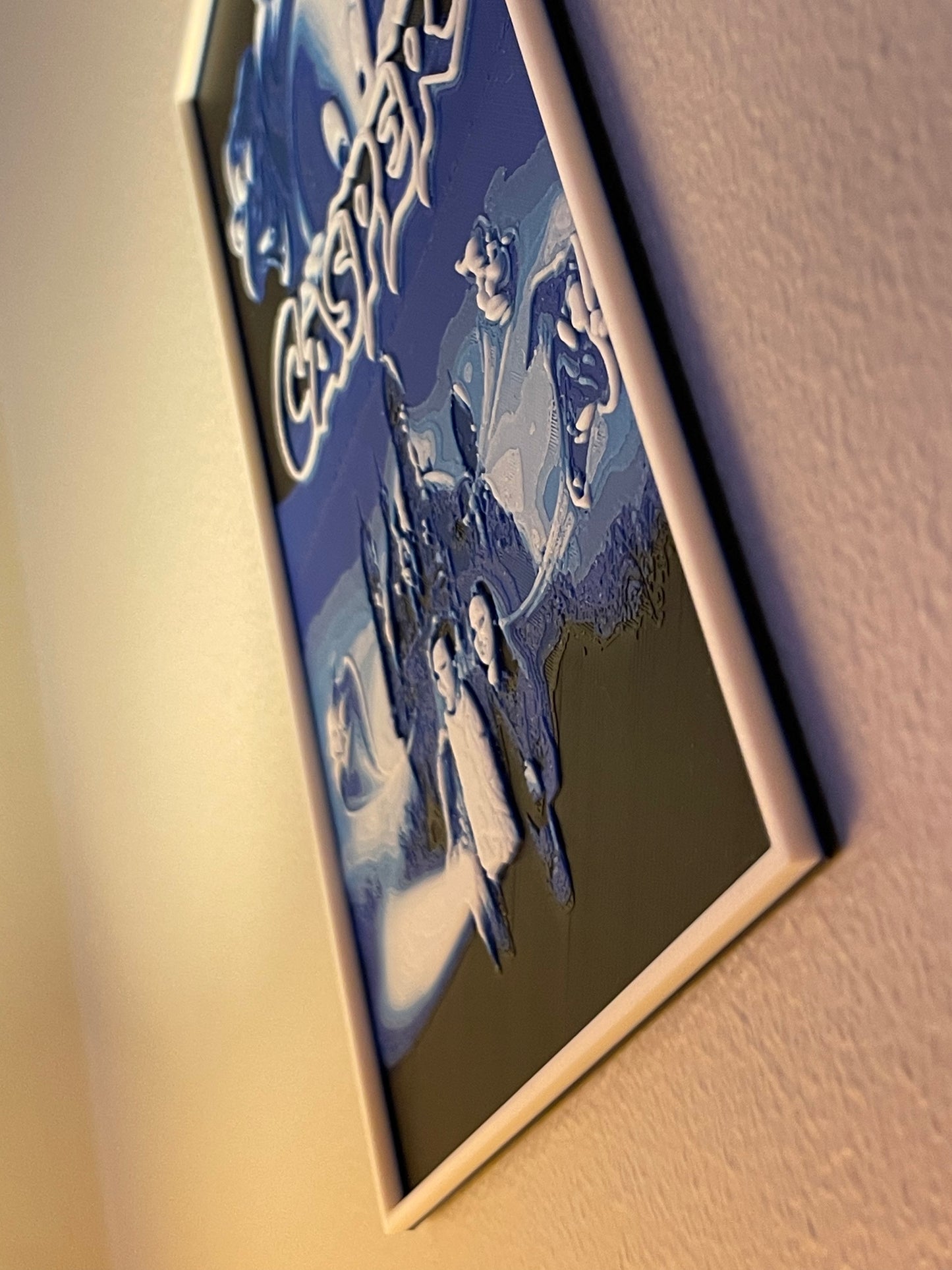 Framed artwork of a couple in a scenic setting on a textured wall.