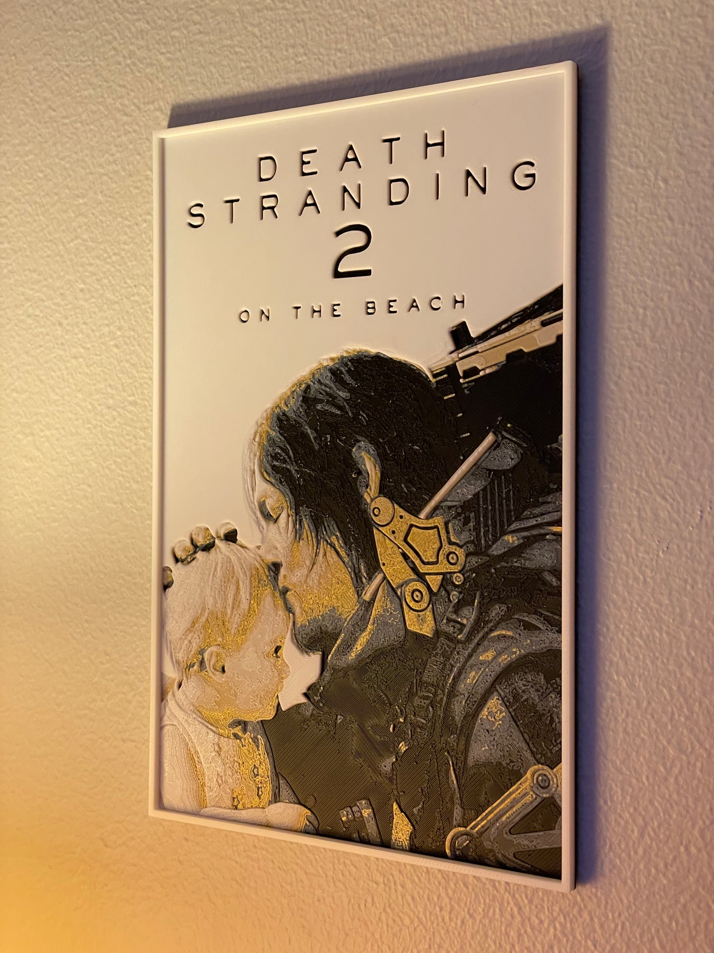 Poster for 'Death Stranding 2: On the Beach' with a character holding a baby against a beige wall.