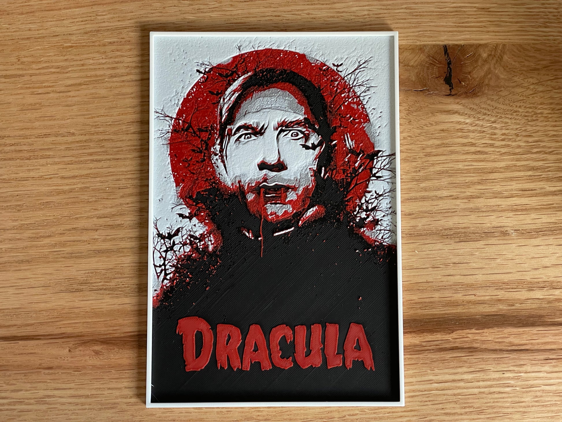 Poster of a character with a red circular design and 'Dracula' text on a wooden surface