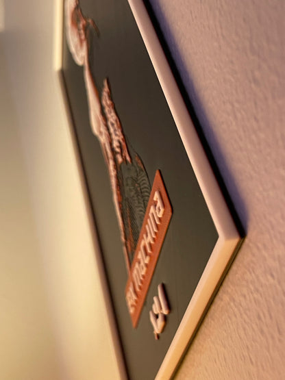 Close-up of a framed picture with a decorative border on a wall.
