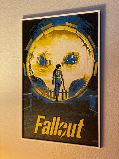 Framed 'Fallout' poster with a character and vault design on a beige wall.