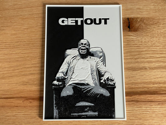 Movie poster for 'Get Out' featuring a person in a chair on a wooden surface