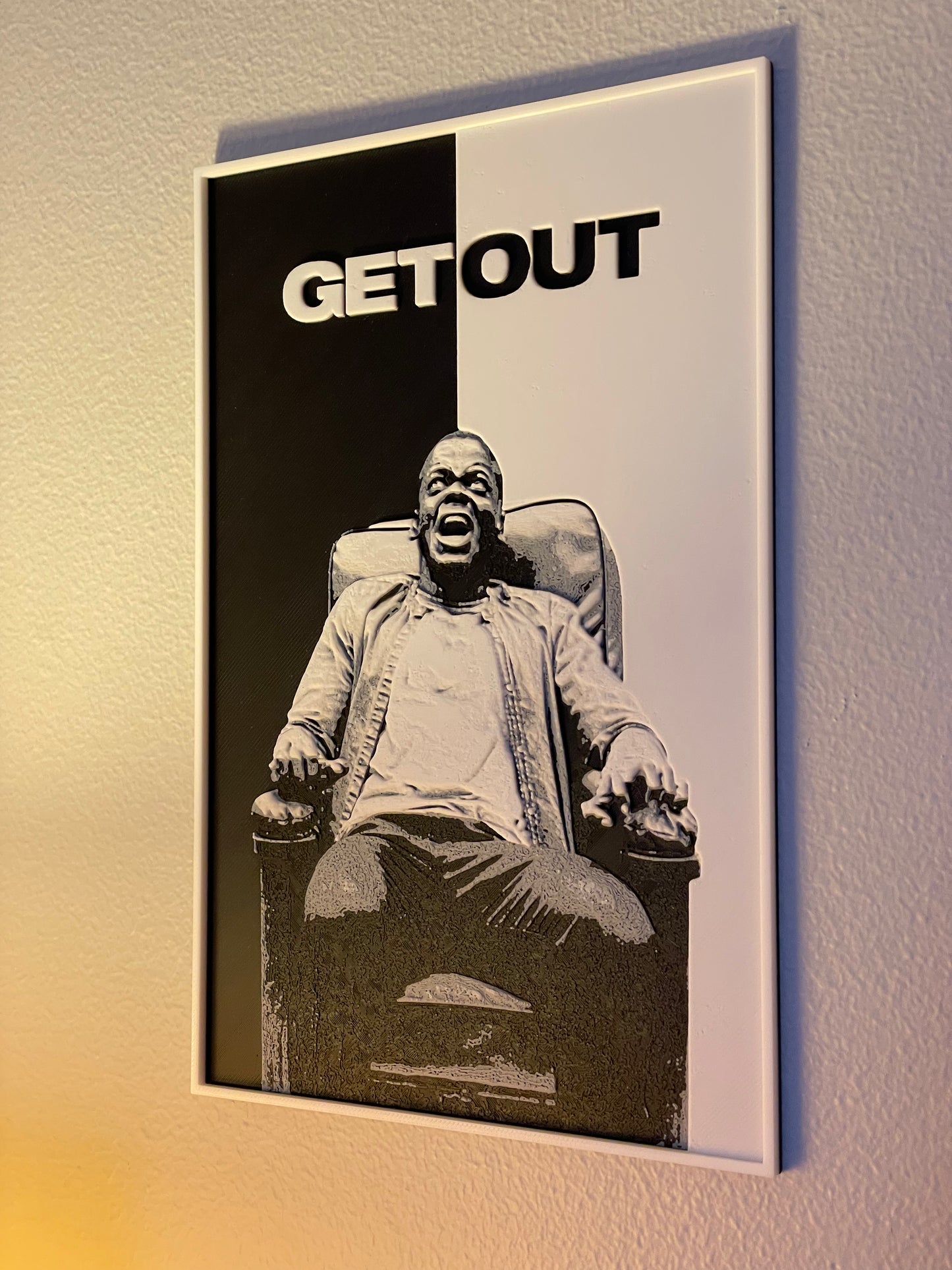 Movie poster for 'Get Out' with a person in a chair on a black and white background.