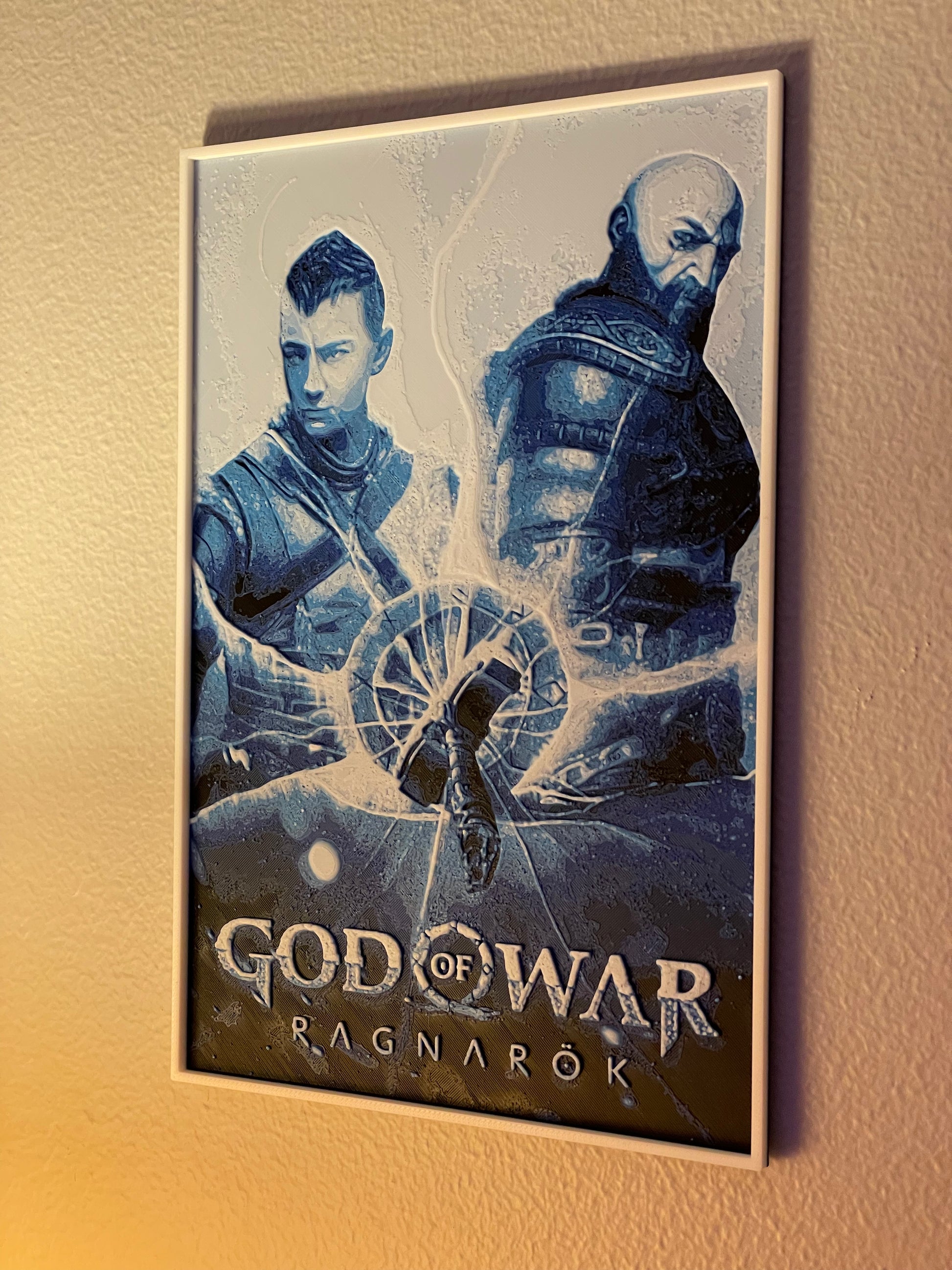 Framed 'God of War Ragnarok' poster with two characters on a beige wall.