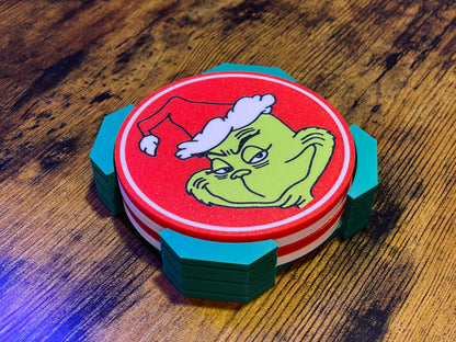 Stack of coasters with a Grinch design on a wooden surface