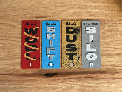 Four rectangular bookmarks with text on a wooden surface