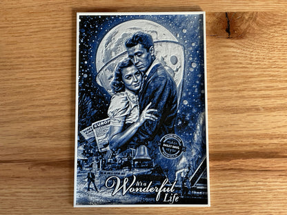 Poster of a couple embracing under a moonlit sky with 'It's a Wonderful Life' text on a wooden surface.