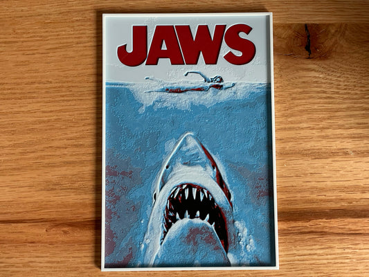 Movie poster for 'Jaws' with a shark and swimmer on a wooden surface