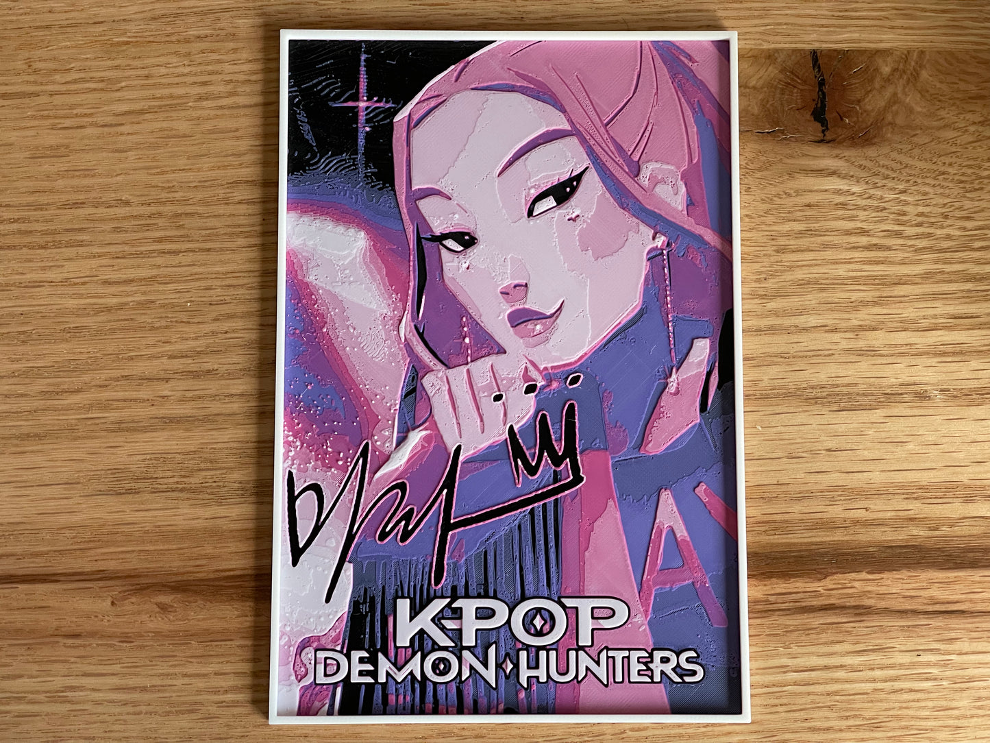 Poster of a character from 'K-Pop Demon Hunters' with stylized text on a wooden surface