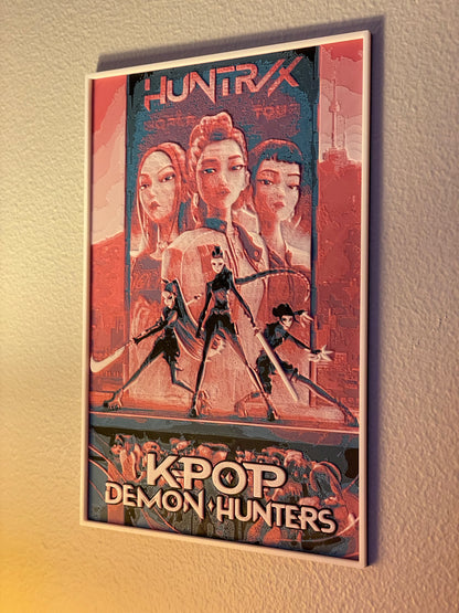 Framed poster of 'Huntrix' featuring four characters with a cityscape background.