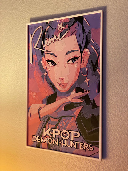 Framed poster of a character with 'K-Pop Demon Hunters' text on a textured wall.