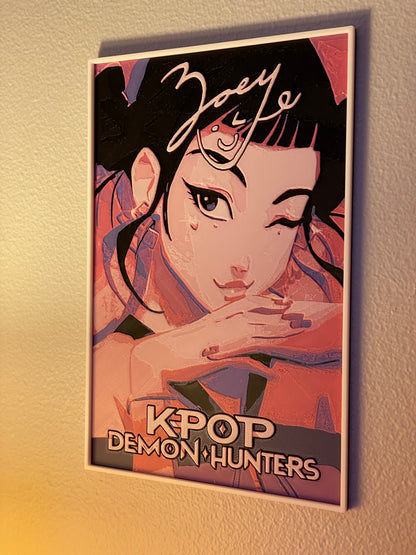 Framed poster of a stylized K-Pop character with decorative elements on a textured wall.
