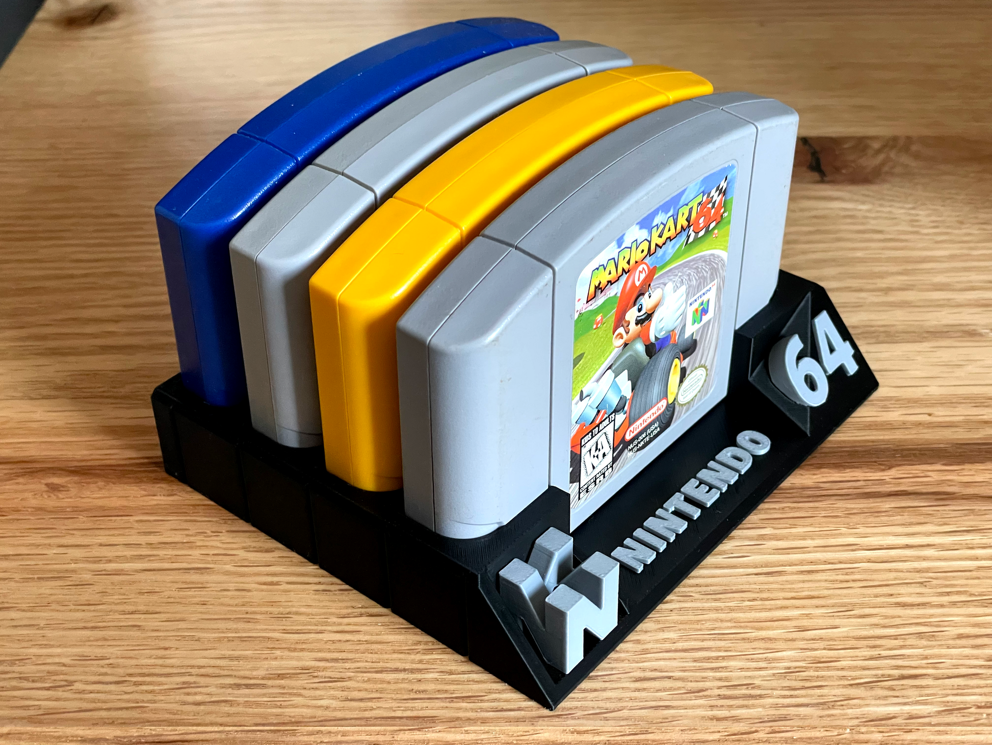 Four Nintendo 64 game cartridges on a stand with a visible 'Mario Kart' cartridge.