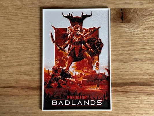 Poster of 'Predator Badlands' with a creature and text on a wooden surface