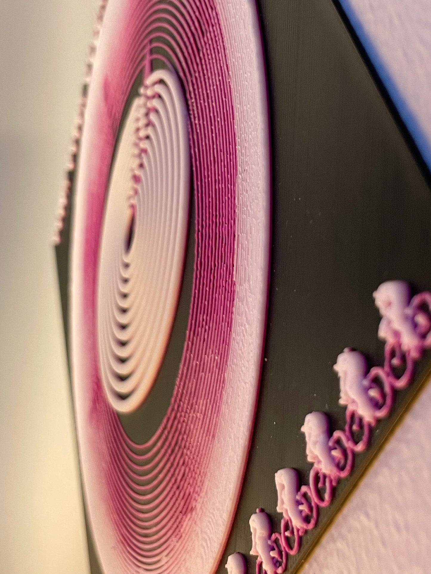 Close-up of a pink and white circular pattern on a black background