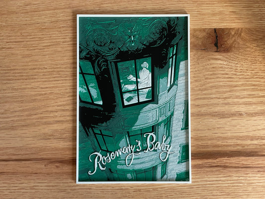 Poster of 'Rosemary's Baby' with a woman looking out a window on a wooden surface