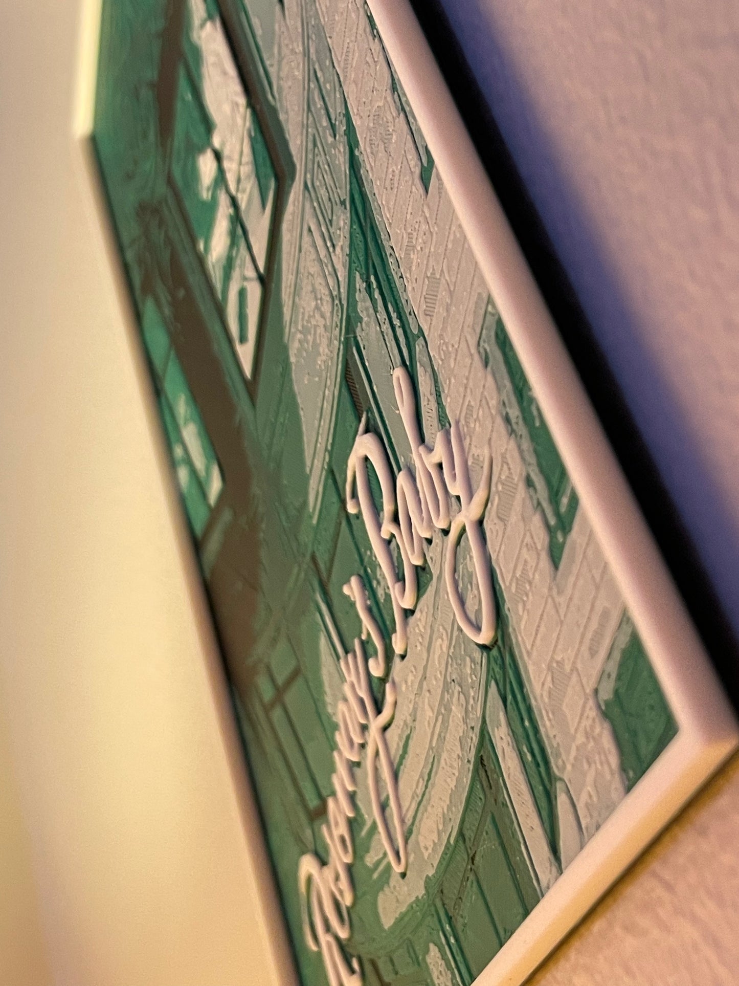 Close-up of a framed poster text on a plain background