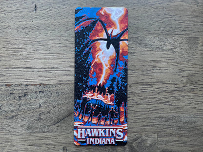 bookmark with a design of a spider and text 'Hawkins Indiana' on a wooden surface