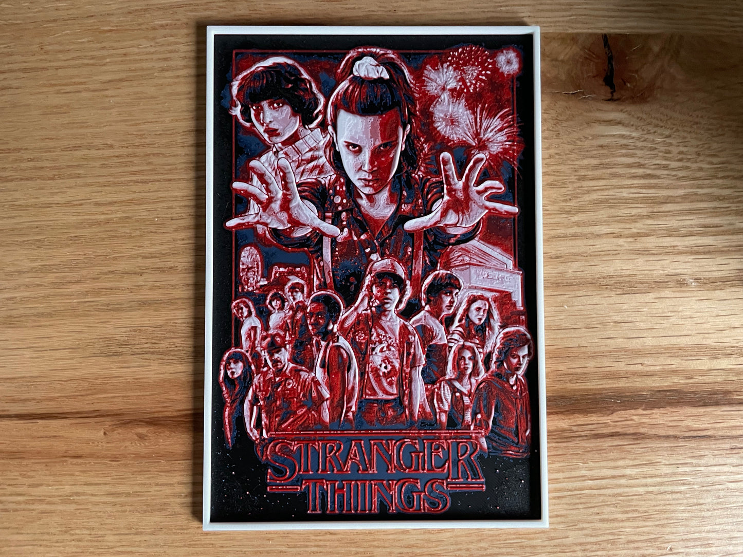 Poster of 'Stranger Things' with characters and text on a wooden surface