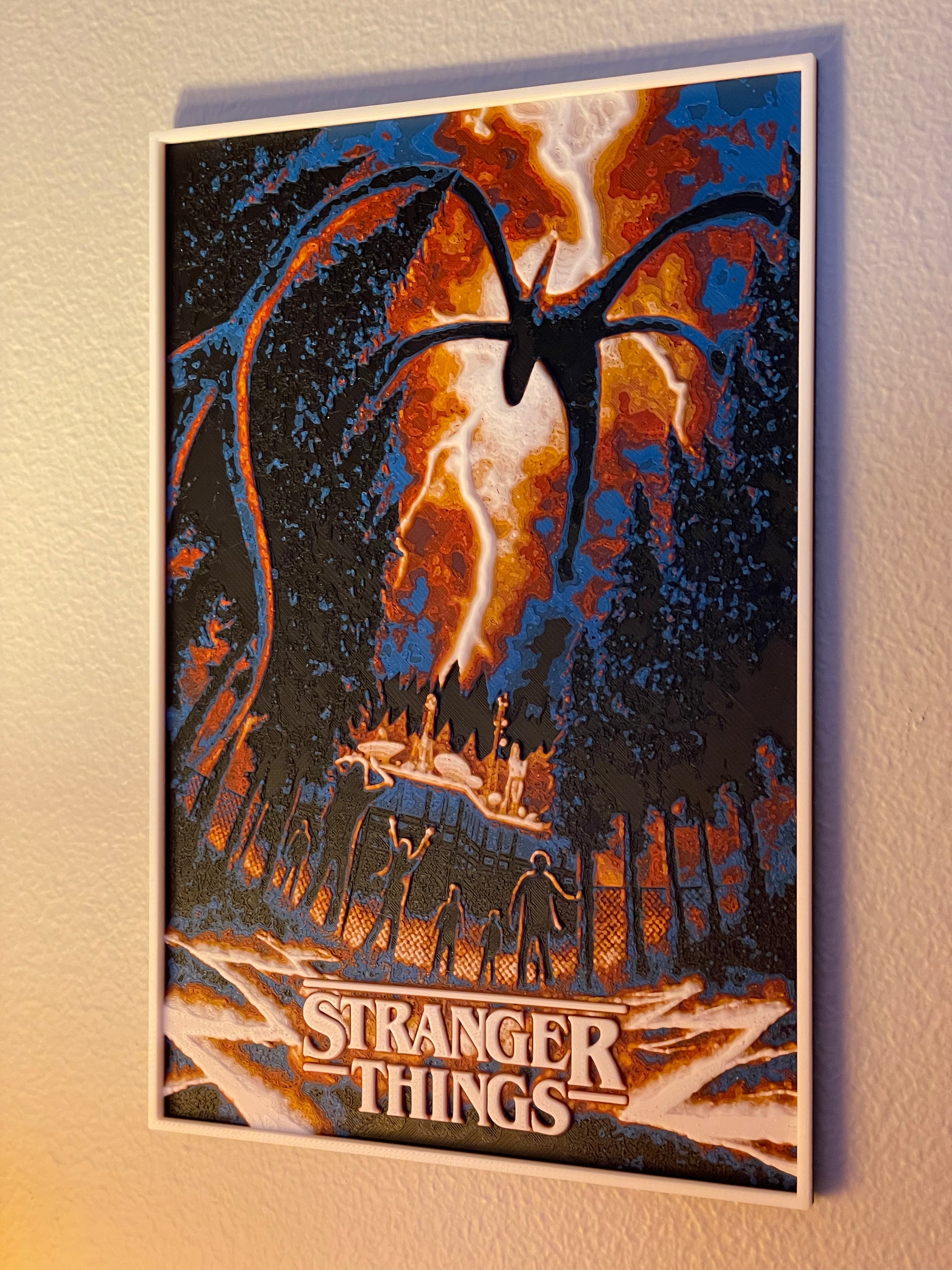 Framed poster of 'Stranger Things' with a silhouette of the Upside Down and people watching.