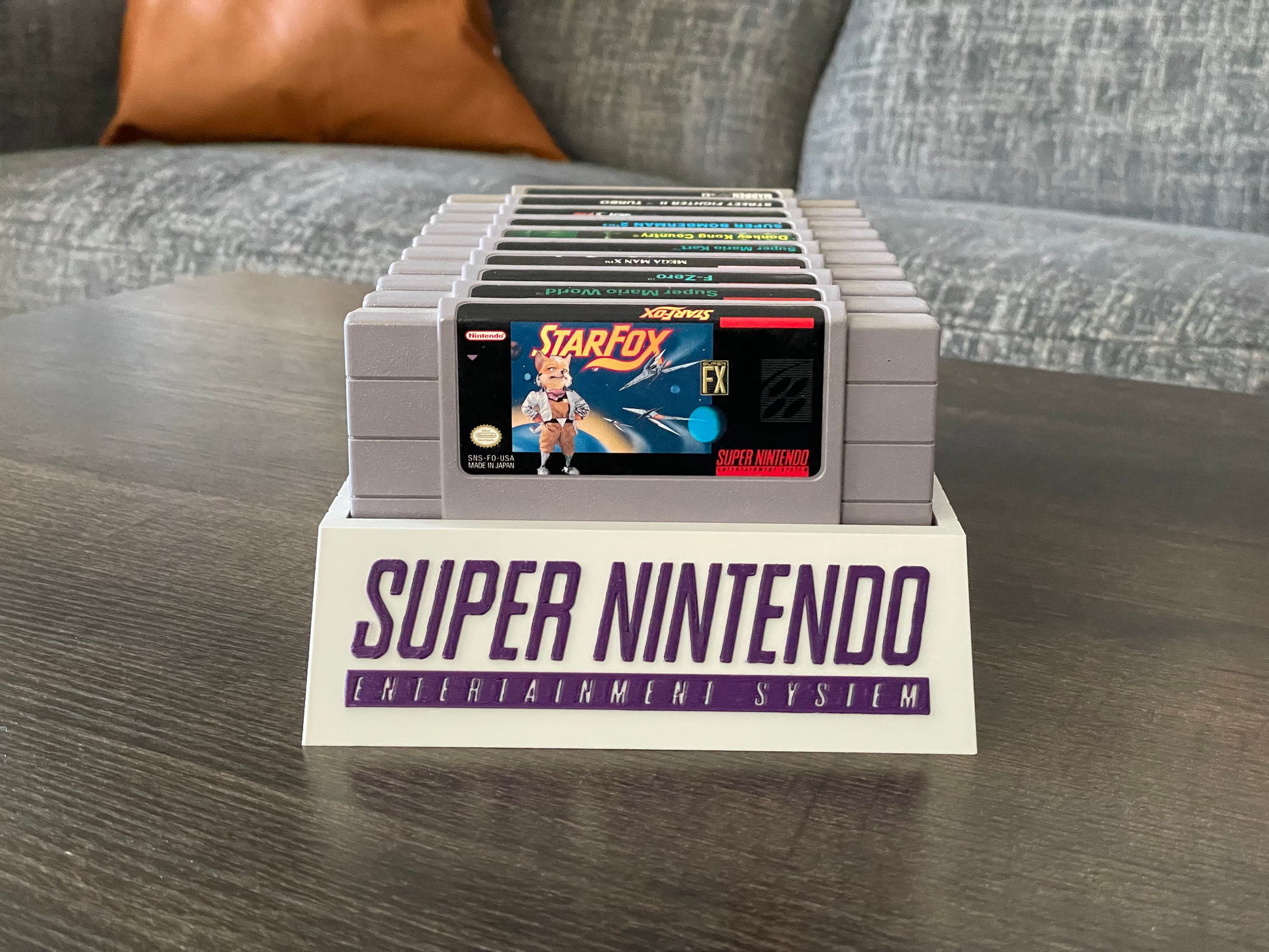 Collection of Super Nintendo Entertainment System cartridges on a stand with 'Star Fox' cartridge displayed.