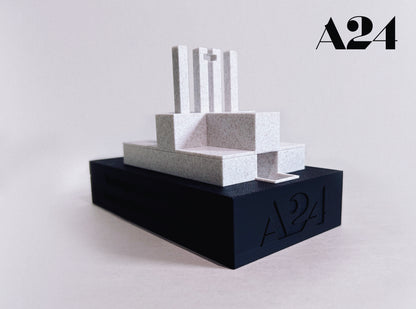 Minimalist sculpture on a black base with 'A24' branding on a light gray background