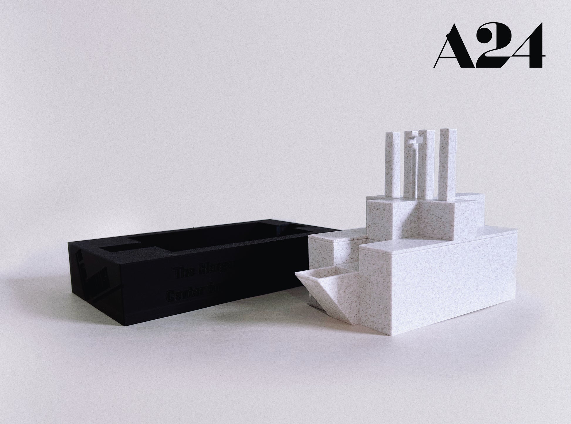 Black rectangular box and white geometric sculpture on a light gray background with A24 logo.