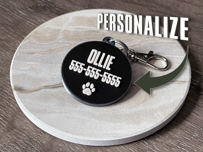 Personalized pet tag with name and phone number on a marble coaster