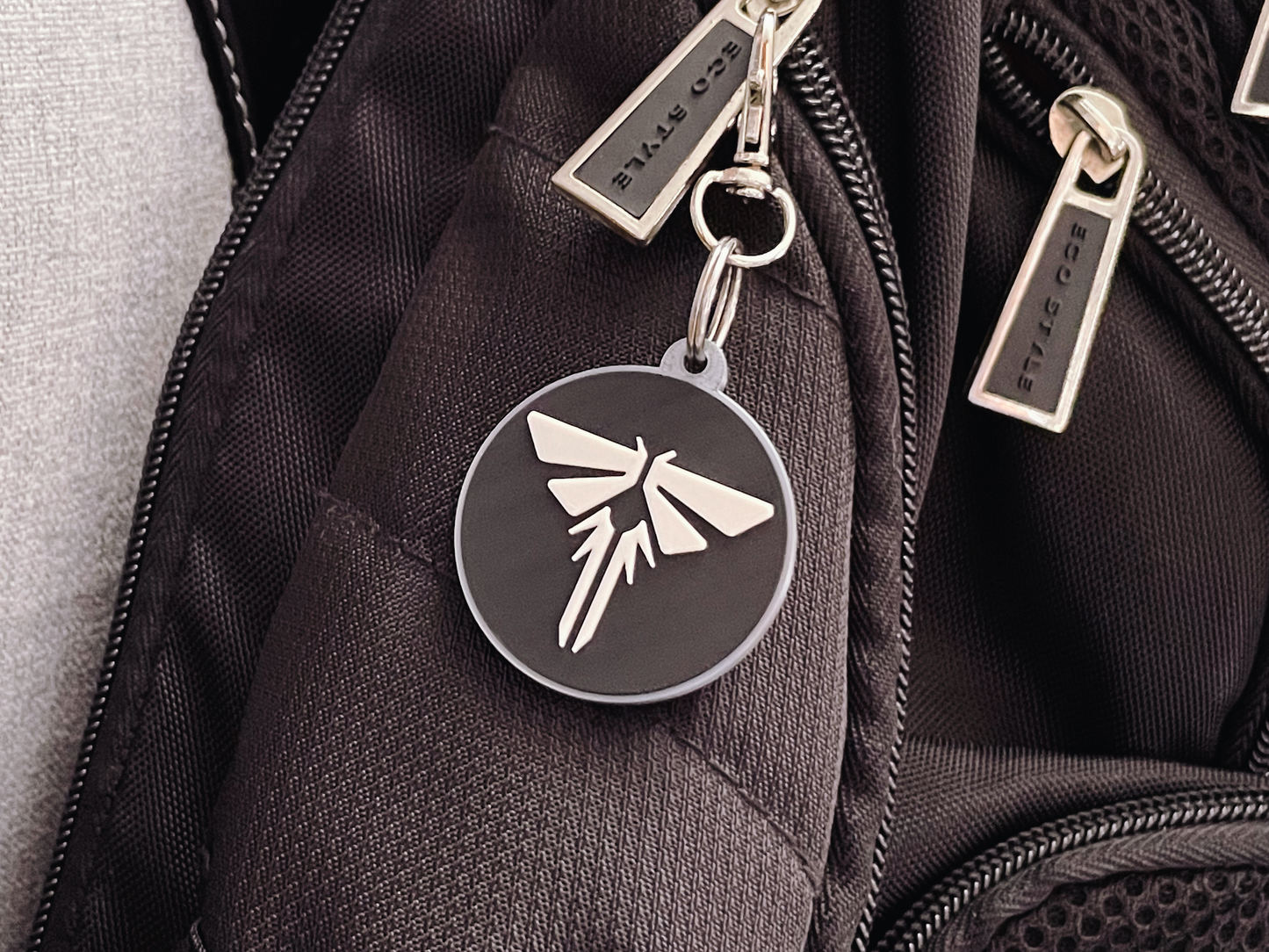 Black backpack with a firefly keychain and visible brand name.