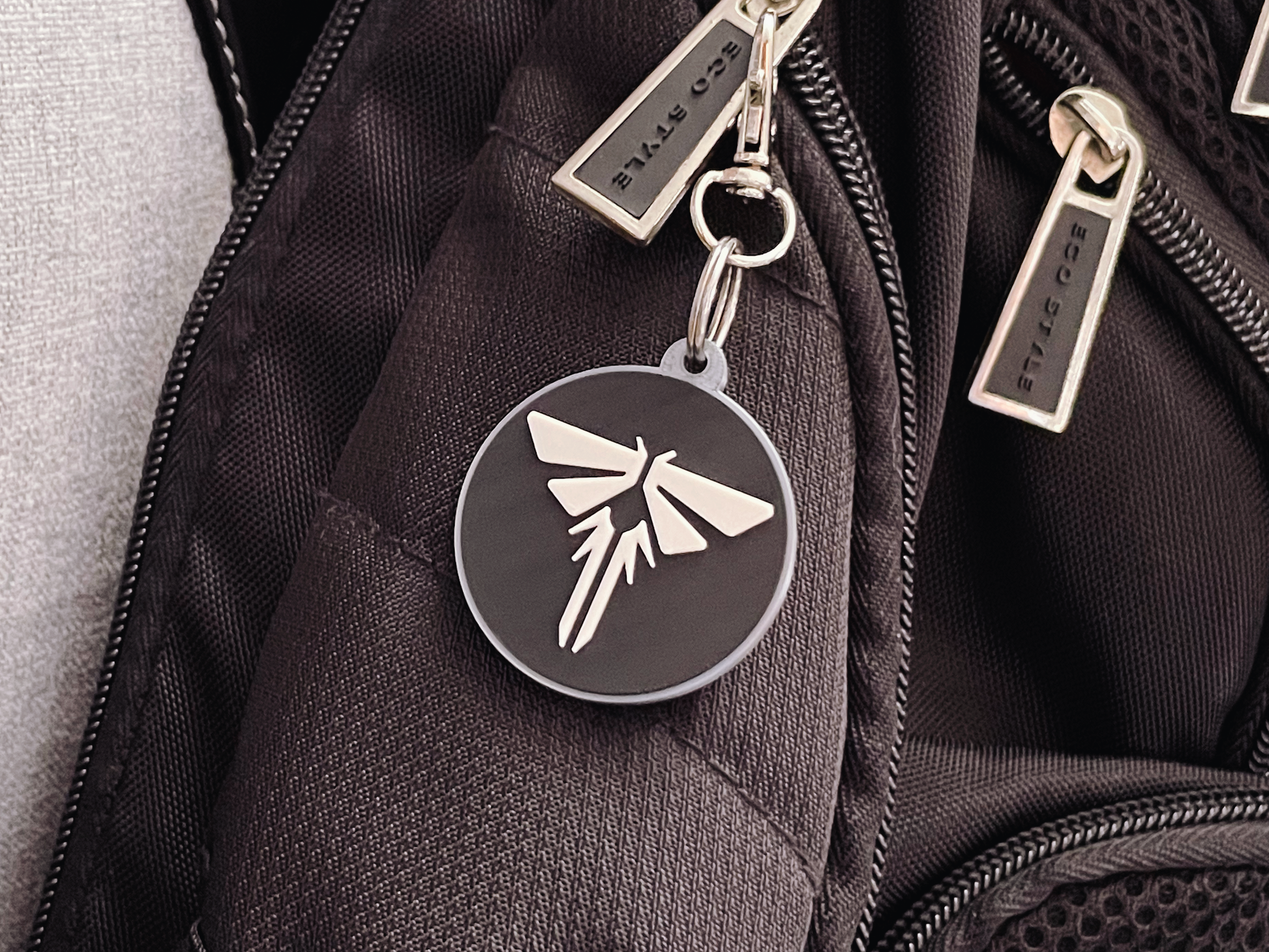 Black backpack with a firefly keychain and visible brand name.