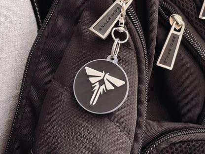 Black backpack with a firefly keychain and visible brand name.