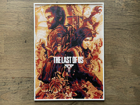Poster of 'The Last of Us' game on a wooden surface