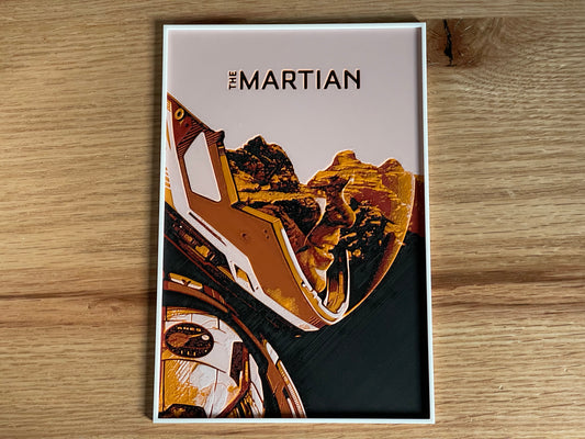 Poster of 'The Martian' with a spacesuit and landscape design on a wooden surface