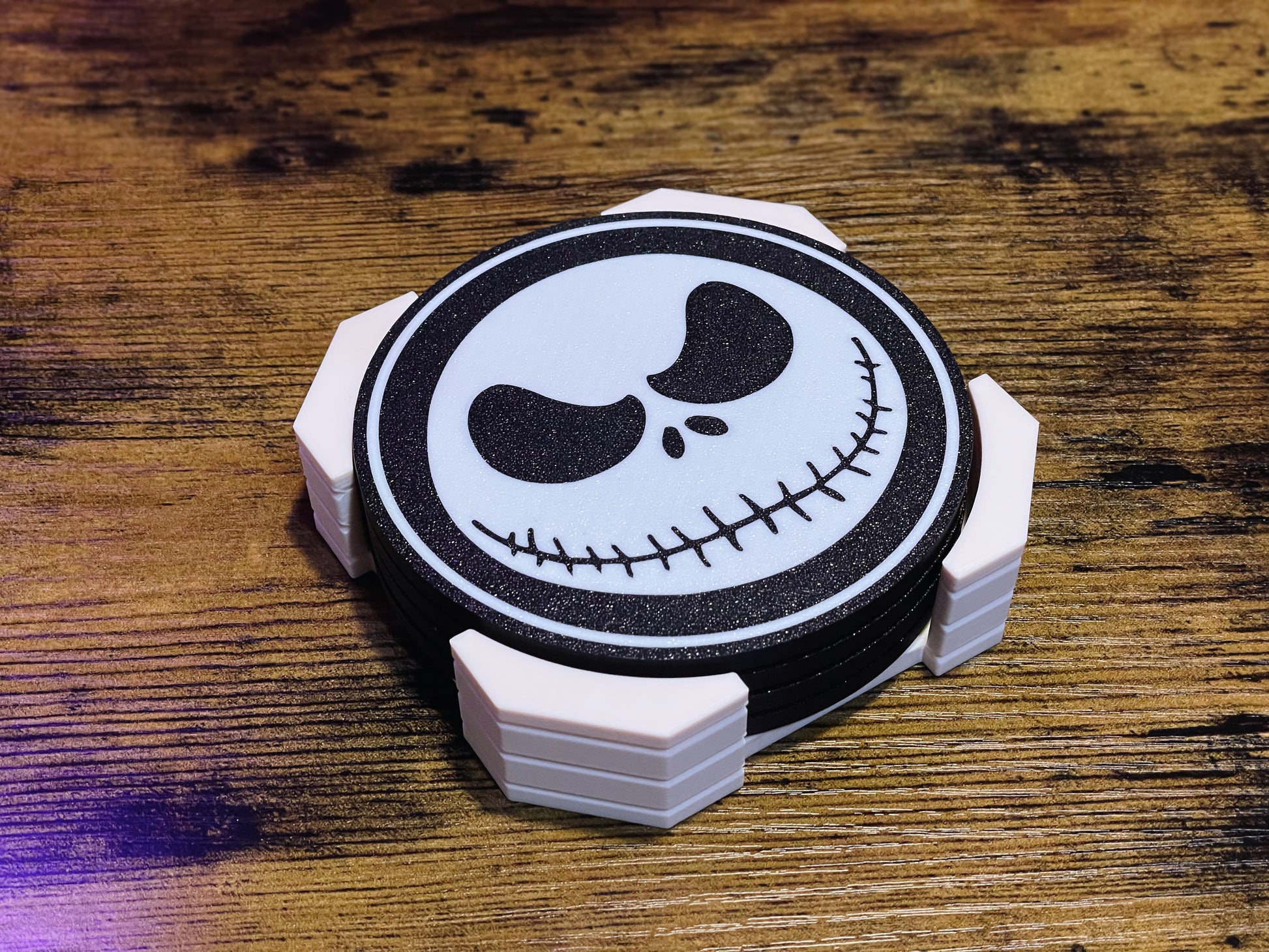 Circular coaster with a skull design on a wooden surface