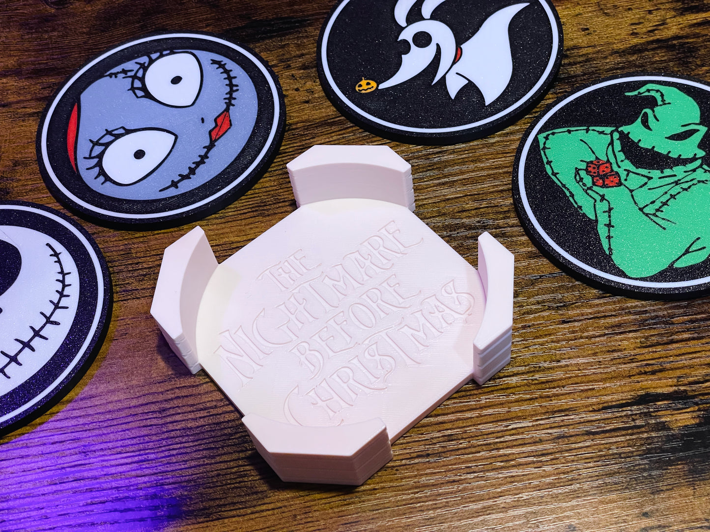 Hexagonal white object with text on a wooden surface surrounded by circular character coasters.