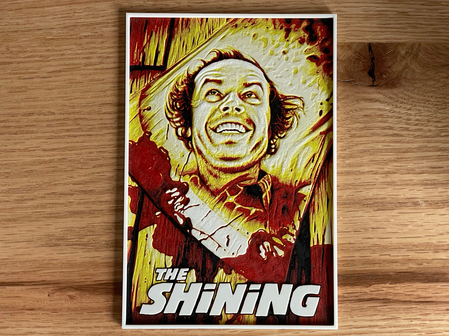 Poster of a character from 'The Shining' on a wooden surface