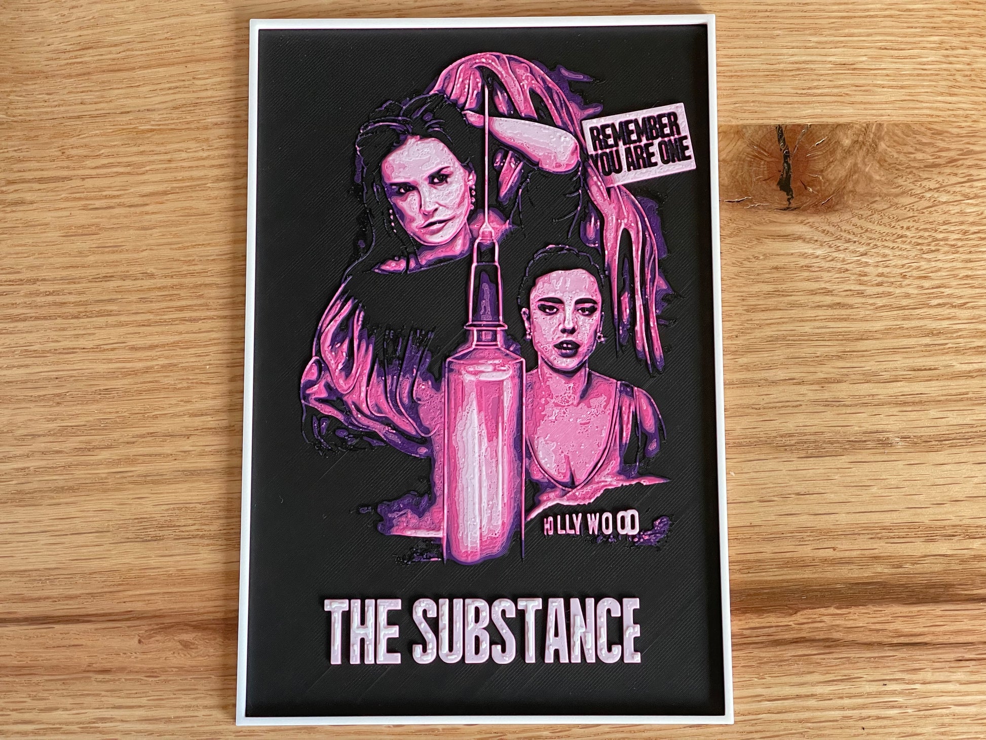 Poster with artistic design of a woman and text on a wooden surface