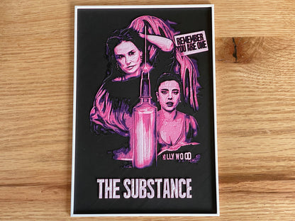 Poster with artistic design of a woman and text on a wooden surface
