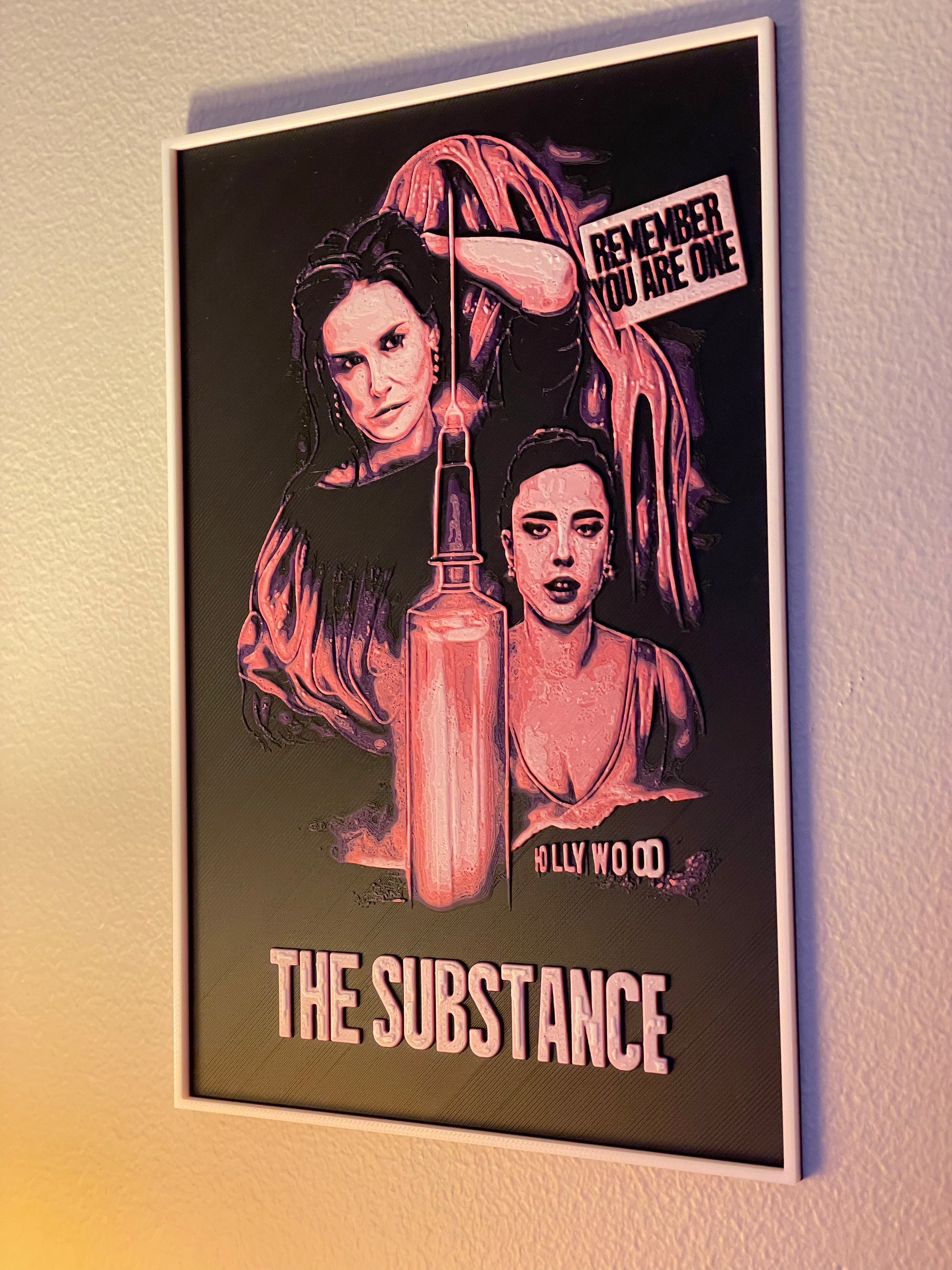 Framed poster of 'The Substance' with a dark background and text.