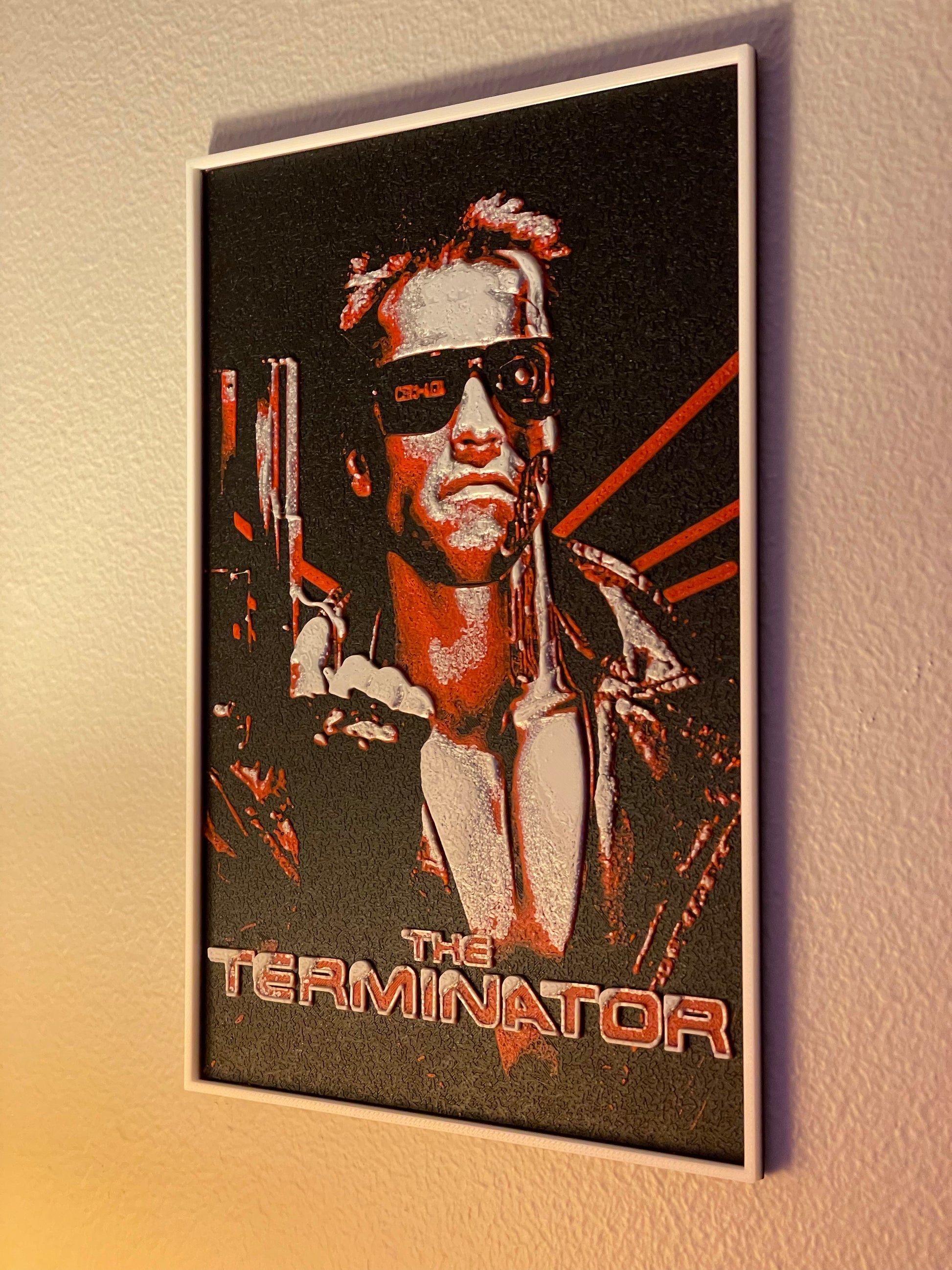 Framed poster of 'The Terminator' character on a wall.
