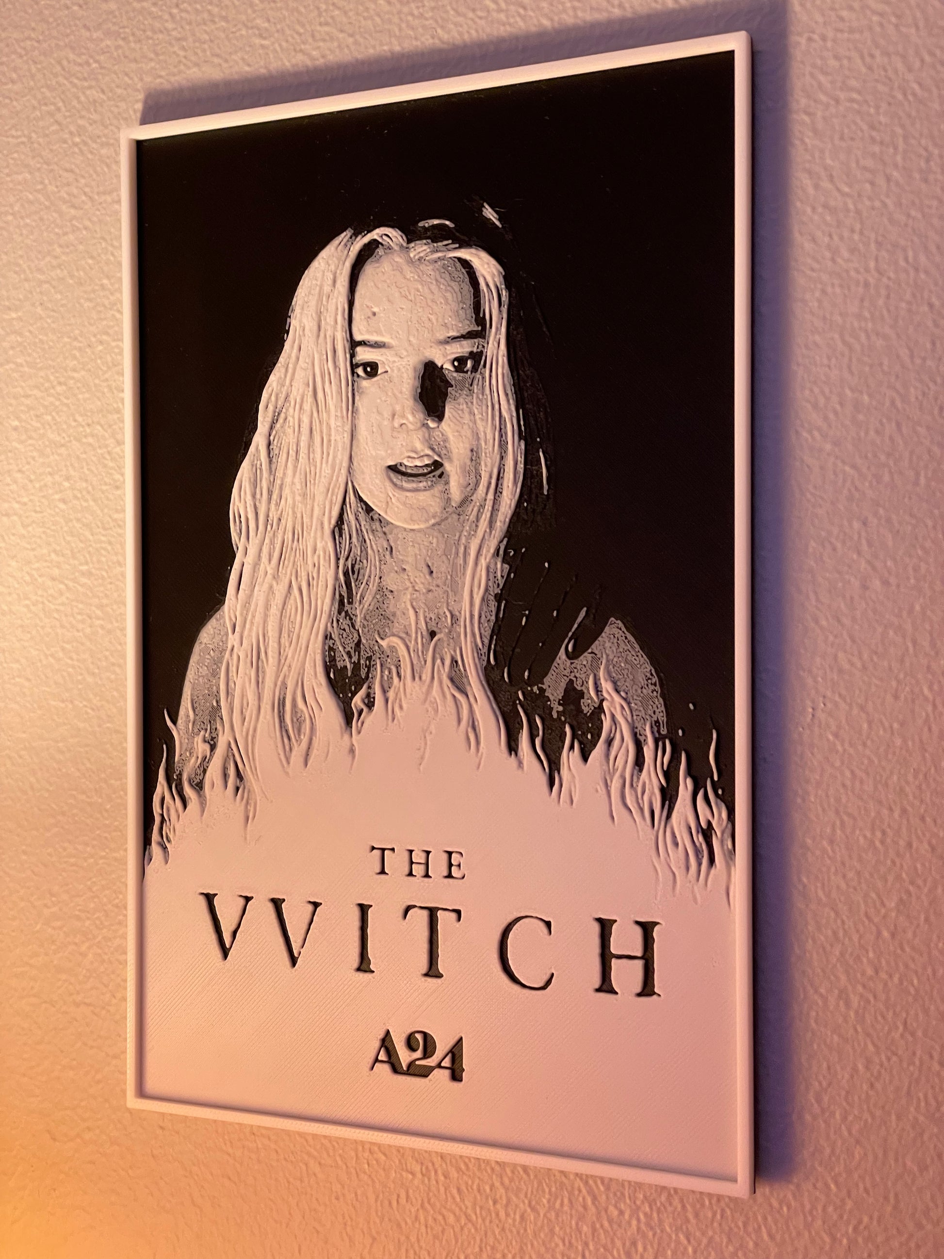 Poster of 'The VVitch' with A24 logo on a wall.